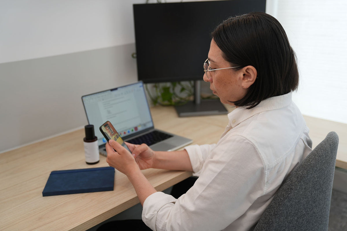 Woman working and looking at smartphone.