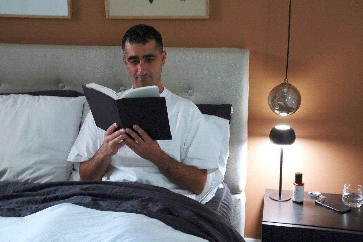 A man reading a book in bed.